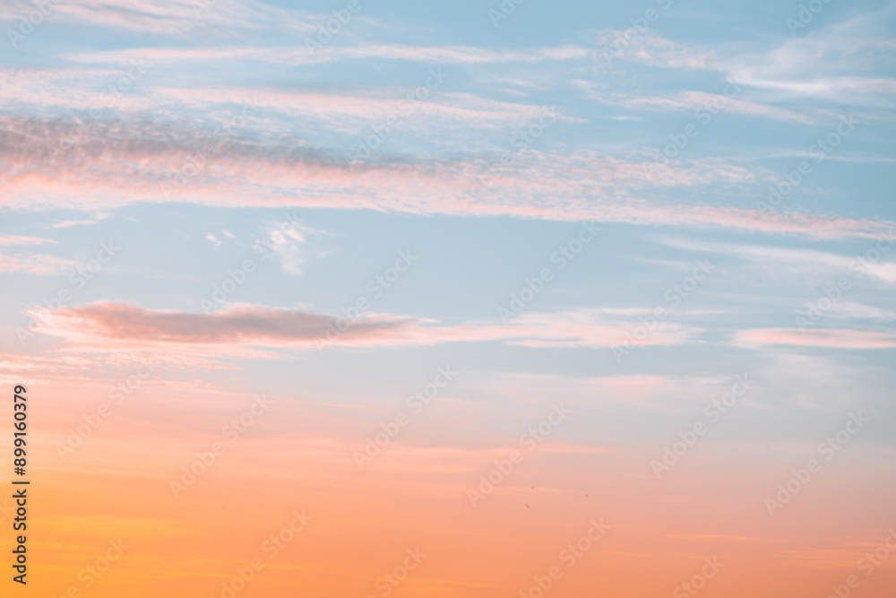 Obraz premium A beautiful sky tinted by the sun leaving vibrant shades of gold, pink, blue and multicolored. Clouds in the twilight evening and morning sky. Cloudy sky background in the evening and during the day.