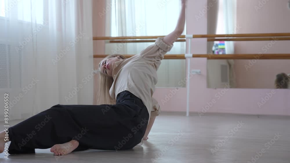 Caucasian woman dancing contemporary on the floor in a ballet class. Caucasian woman dancing contemporary on the floor in a ballet class.