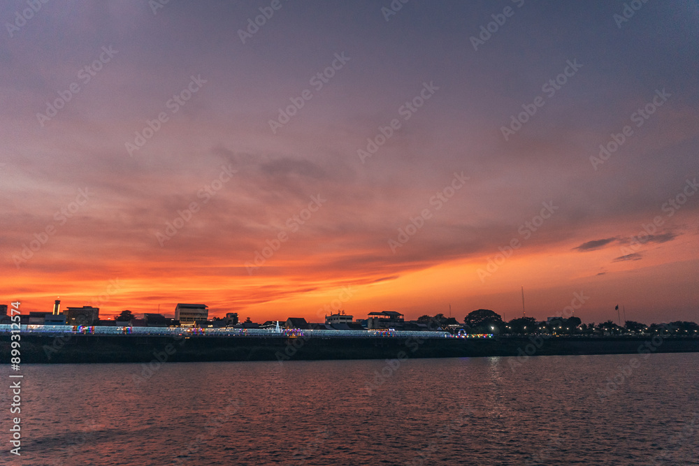 Sunset along the Mekong River. Mekong River connects Thailand to Laos. Nakhon Phanom is along Mekong River opposite Thakhek, Khammouan of Laos. Sunset along the Mekong River. Mekong River connects Thailand to Laos. Nakhon Phanom is along Mekong River opposite Thakhek, Khammouan of Laos.