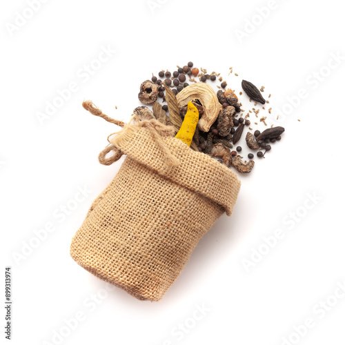 Top view of organic whole spices spilled out from a jute bag, used to make a digestive powder called 