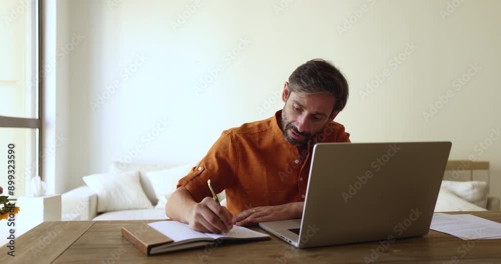 Serious Hispanic freelance project manager man in casual talking on video call, speaking at laptop, writing notes, working at home workplace table. Adult student attending online conference chat Serious Hispanic freelance project manager man in casual talking on video call, speaking at laptop, writing notes, working at home workplace table. Adult student attending online conference chat