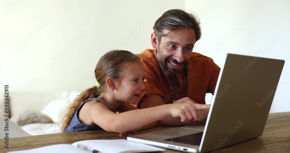 Happy middle aged Hispanic dad and excited little girl playing virtual learning game on laptop, pointing following finger at display, monitor, watching funny content, laughing Happy middle aged Hispanic dad and excited little girl playing virtual learning game on laptop, pointing following finger at display, monitor, watching funny content, laughing