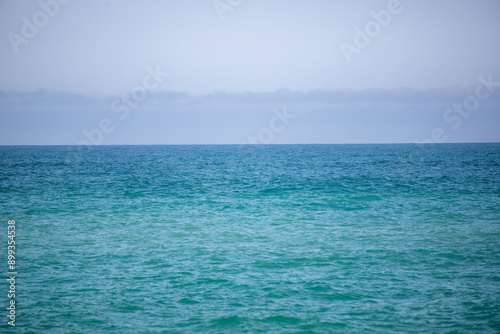 Blue sea and blue sky with white clouds. Seascape.