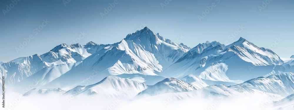 Fototapeta premium A towering mountain, completely snow-capped, dominates a clear blue sky with scattered clouds in the foreground
