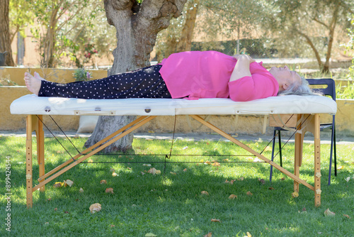 woman lying on a stretcher in the garden photo