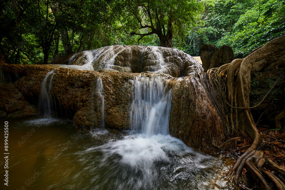 Naklejka premium Scenic view of waterfall in forest