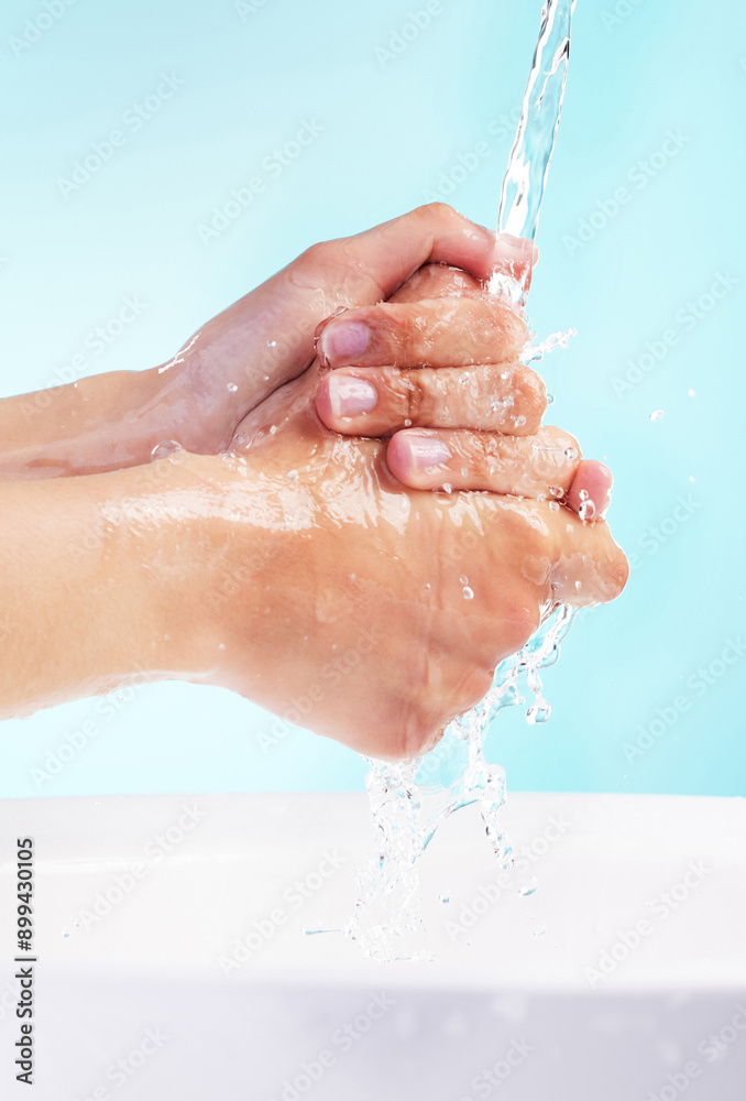 Fototapeta premium Person, water and washing of hands in studio for bacteria, hygiene and germ protection in basin. Cleaning, skin hydration and body care with liquid for disinfectant or virus safety on blue background