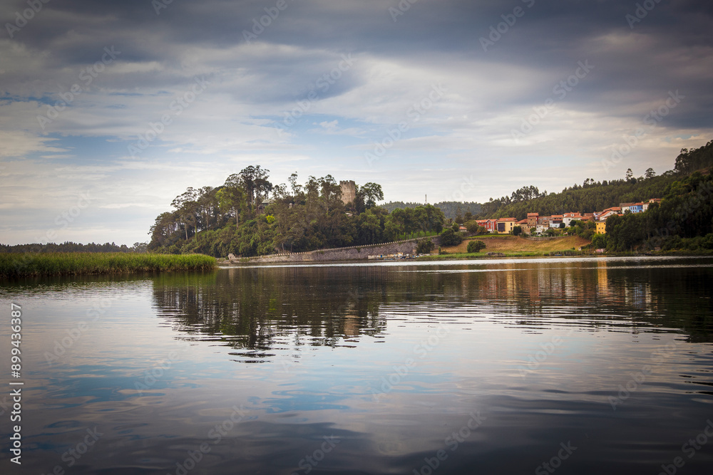 Beautiful panoramic landscape of the El Castillo village and pier from the estuary in Soto del Barco. Asturias. Spain Beautiful panoramic landscape of the El Castillo village and pier from the estuary in Soto del Barco. Asturias. Spain
