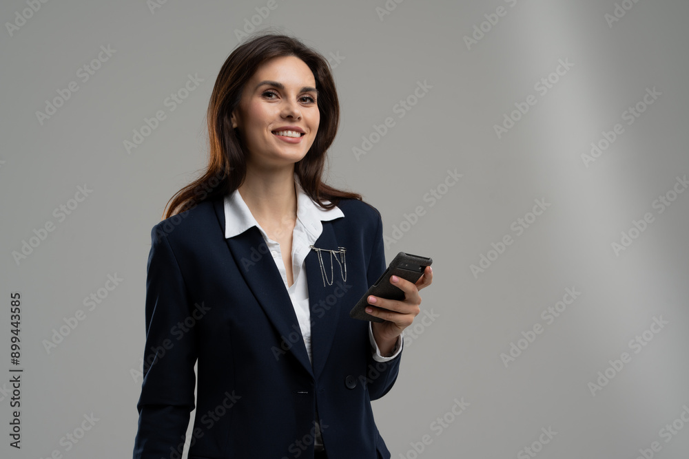 A woman in formal wear, smiling with a microphone in hand at an event A woman in formal wear, smiling with a microphone in hand at an event