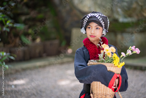 Portrait fashion of younger cute Hmong or Yao Hill Tribes teenagers in beautiful traditional dress costumes with flowers in bamboo baskets. photo