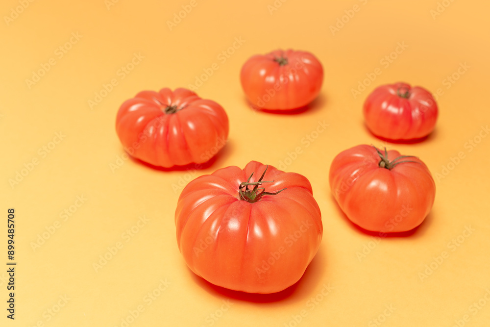 Close-up of pink tomatoes on background of pastel yellow color. Close-up of pink tomatoes on background of pastel yellow color.