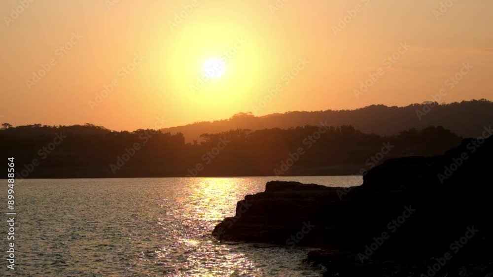 Dramatic view of the lake at sunset. The round sun gave off golden yellow light. The sunset view creates a feeling of relaxation and calm. Footage 4K,60fps Dramatic view of the lake at sunset. The round sun gave off golden yellow light. The sunset view creates a feeling of relaxation and calm. Footage 4K,60fps