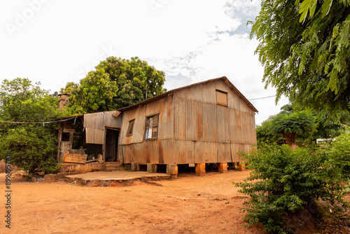 Weathered Corrugated Iron Shack in an African Suburb, Built During Colonial Times, Elevated on Stilt Foundations with Aging Earth Brick Pillars