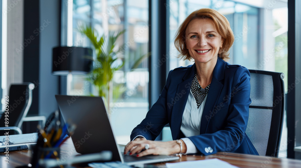 A smiling businesswoman in a modern office, seated at a desk with a laptop, exuding confidence and professionalism. A smiling businesswoman in a modern office, seated at a desk with a laptop, exuding confidence and professionalism.