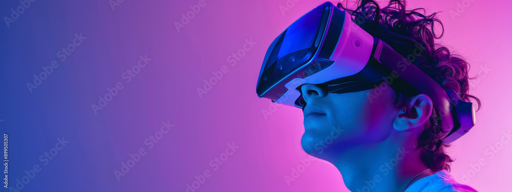 Innovative Young Man Engaged in Virtual Reality Experience Under Colorful Lighting at Tech Event Innovative Young Man Engaged in Virtual Reality Experience Under Colorful Lighting at Tech Event