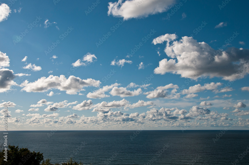 Obraz premium 静かな海と青空に浮かぶ白い雲