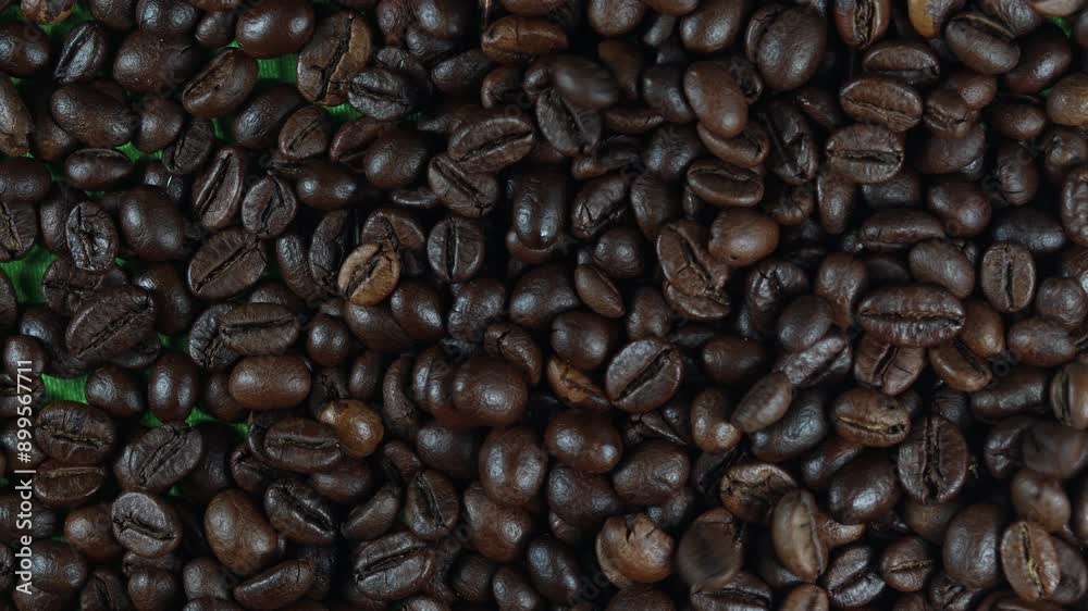 flat lay angle of falling coffee beans covered the screen on a green background.
flat lay angle of falling coffee beans covered the screen on a green background.