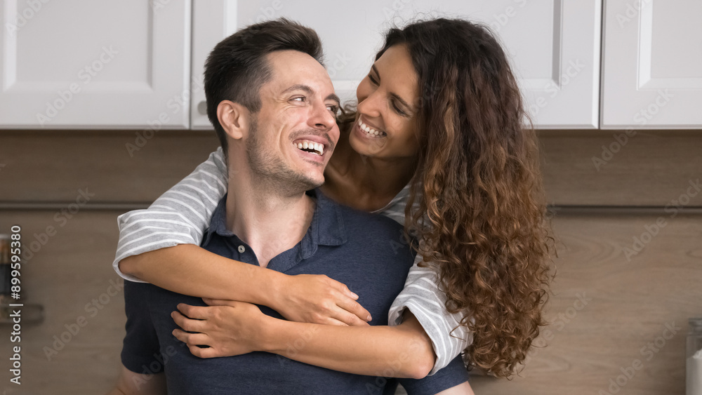 Fototapeta premium Loving Hispanic spouses spend time together in renovated modern kitchen, loving wife snuggle tightly husband, expressing love and affection. Bank loan, tenancy, romantic relationships, happy marriage