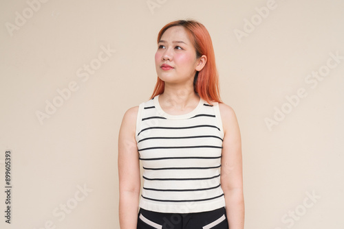 Portrait of Beautiful Asian Woman Thinking Against Plain Background