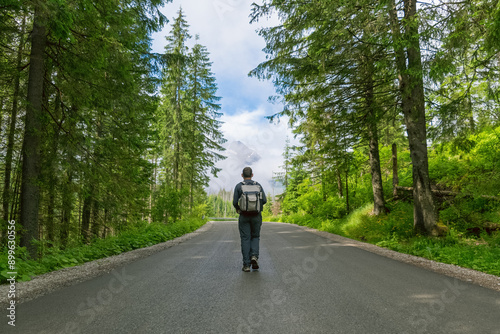 A man on a mountain road. Hiking in the mountains in summer. Road to Morskie Oko. Tatras