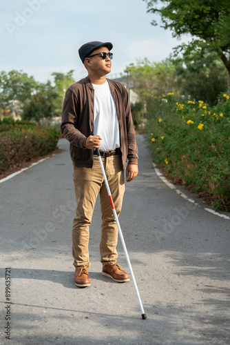 Obraz na plátne Young blind man walking in city with walking stick