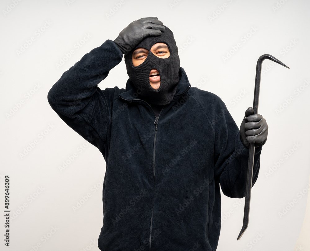 Thief in uniform black jacket various pose on isolated background. The Robber terrorism criminal escapes with balaclava and crowbar entering a house for stealing Housebreak Thief in uniform black jacket various pose on isolated background. The Robber terrorism criminal escapes with balaclava and crowbar entering a house for stealing Housebreak