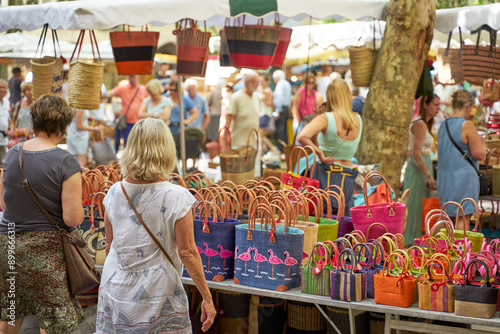 Fototapeta Naklejka Na Ścianę i Meble -  People looking at goods at the Uzès market, one of the most beautiful in France