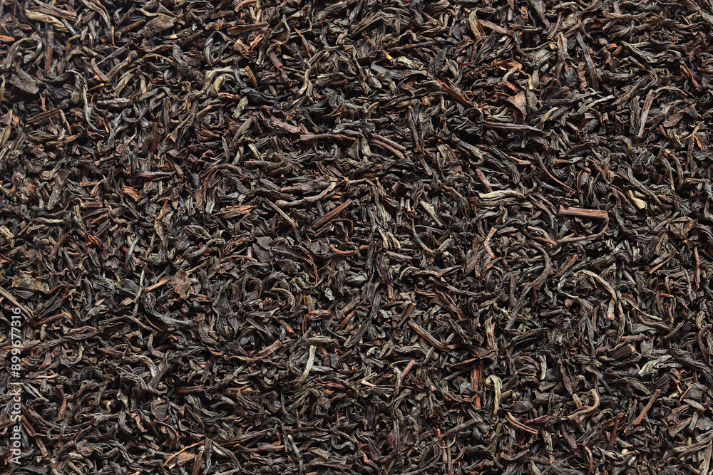 Long black tea, texture. Top view of dried tea leaves. Tea composition. Ingredients for a hot drink, close-up. Background Long black tea, texture. Top view of dried tea leaves. Tea composition. Ingredients for a hot drink, close-up. Background