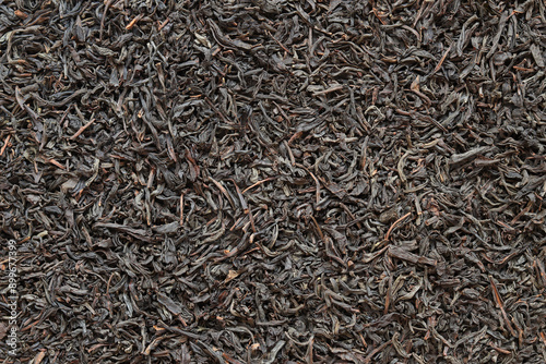 Long black tea, texture. Top view of dried tea leaves. Tea composition. Ingredients for a hot drink, close-up. Background