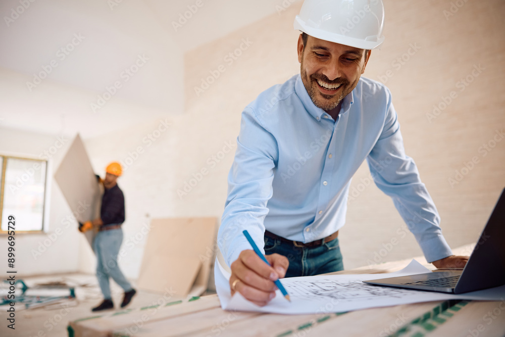 Happy architect analyzing housing plans during home remodeling project. Happy architect analyzing housing plans during home remodeling project.