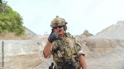 Soldier in camouflage gear with his thumbs up, ready for battle.