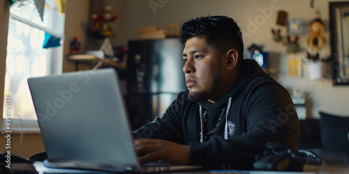 Wallpaper Mural hispanic man sits in front of a laptop, engaged in a video call with a group of people on the screen. Torontodigital.ca
