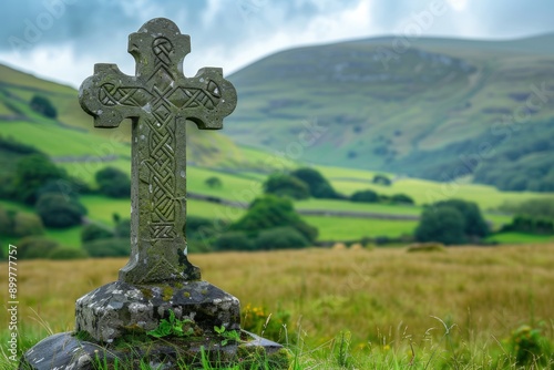 A large stone cross is standing in a field of grass