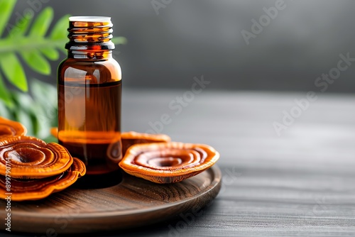 Close-up of Reishi mushroom extract in a glass bottle, surrounded by dried Reishi mushrooms on a wooden tray.