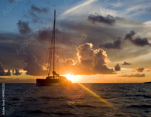 Eco catamaran sailing during an amazing colorful sunset in the caribbean sea anchored
