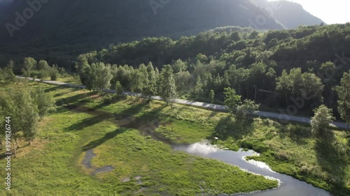 drone aerial view over golf field in andalsnes norway on a summer evening with sun and mountains in the background