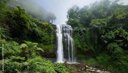 Una cascada imponente que cae desde una gran altura, rodeada de vegetación