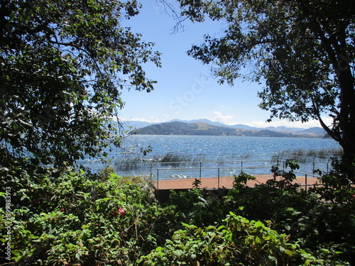 vista del muelle en el lago con vegetación y montañas  photo