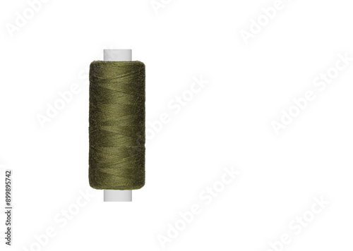 green spool of sewing thread isolated on white background close up photo