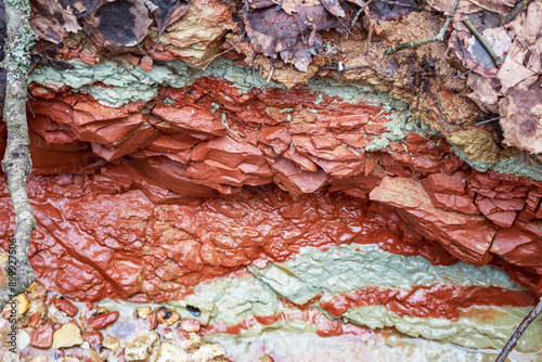 Texture of variegated red-blue clay exposed along the banks of a stream