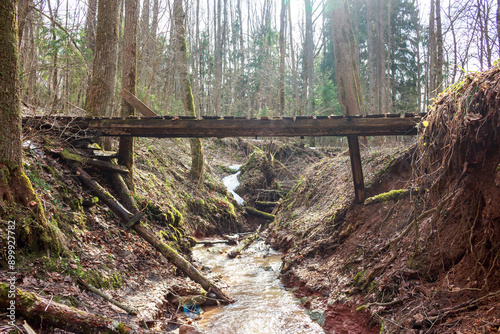 Pedestrian bridge spanning a ravine with a stream photo