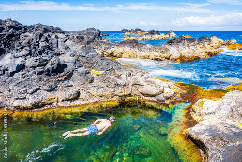 Obraz na płótnie Unidentified man snorkelling in natural swimming pools on rocky coast in Mosteiros town, Sao Miguel island, Azores, Portugal w salonie