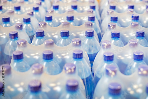 drinking water packaged in plastic containers on the shelves in the supermarket