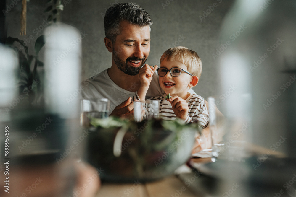 Happy father and son having food at dining table Happy father and son having food at dining table