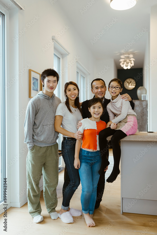 Full length portrait of family posing with each other at home Full length portrait of family posing with each other at home