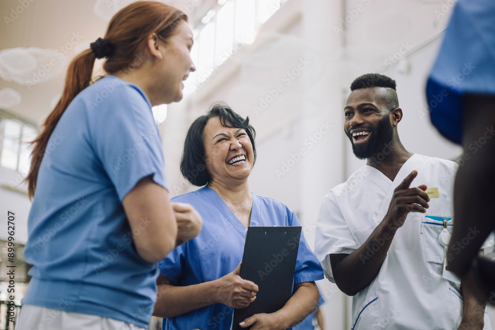 Happy male and female medical experts discussing with each other in hospital Happy male and female medical experts discussing with each other in hospital
