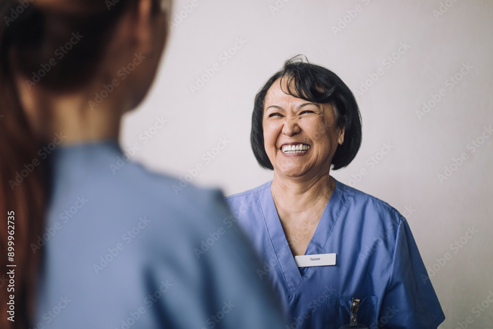 Happy senior female physician talking with female colleague Happy senior female physician talking with female colleague