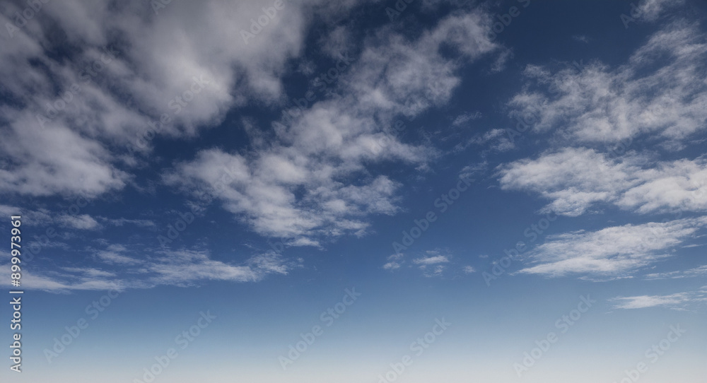 Wolkiger Himmel mit verstreuten, weißen Wolken, die sich vor einem klaren, blauen Hintergrund abheben und eine leichte, sommerliche Atmosphäre schaffen Wolkiger Himmel mit verstreuten, weißen Wolken, die sich vor einem klaren, blauen Hintergrund abheben und eine leichte, sommerliche Atmosphäre schaffen