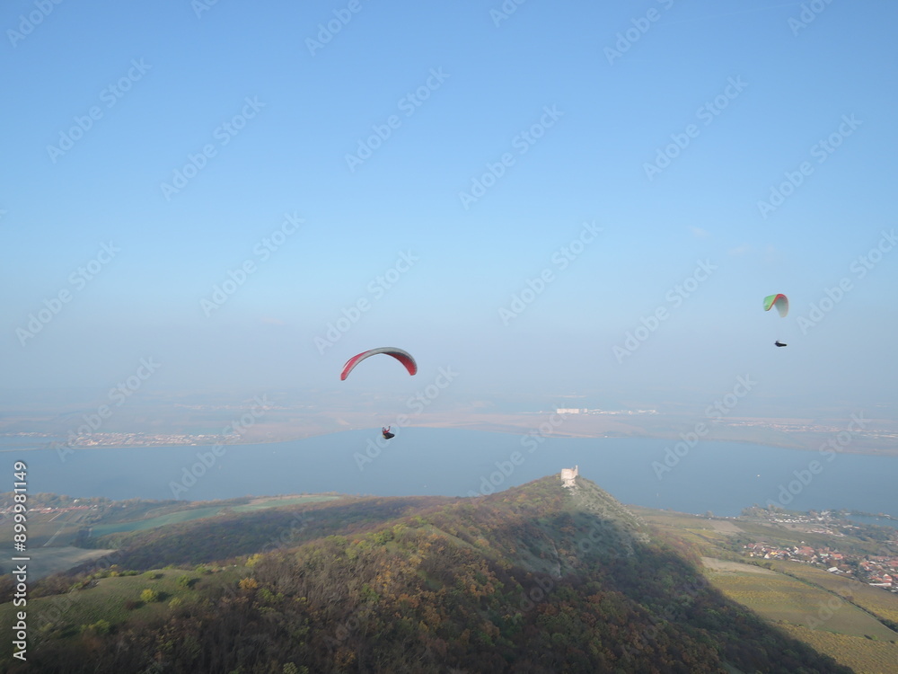 Paragliding over the Palava mountain range in Moravia, Czech Republic. A breathtaking experience, flying over a natural reserve with stunning views of the landscape.
Paragliding over the Palava mountain range in Moravia, Czech Republic. A breathtaking experience, flying over a natural reserve with stunning views of the landscape.