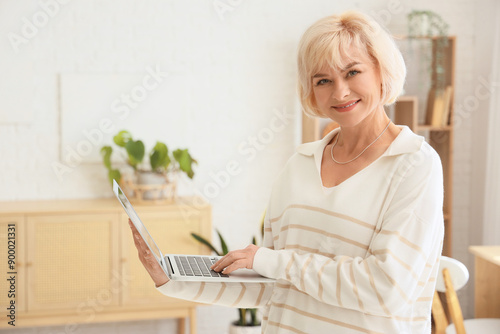 Mature woman using laptop f...